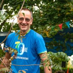 Mitarbeiter der VG Verbrauchergemeinschaft mit einem Jubiläums-Tshirt