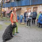Mann mit Hund spricht auf Biohof