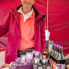 Eine Produktpalette von Aronia Original auf einem Tisch, eine Mitarbeiterin