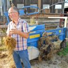 Bio-Bauer hält Stroh in der Hand und erklärt