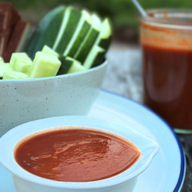 Eine kleine Schüssel Rhabarberketchup und geschnittenes Gemüse