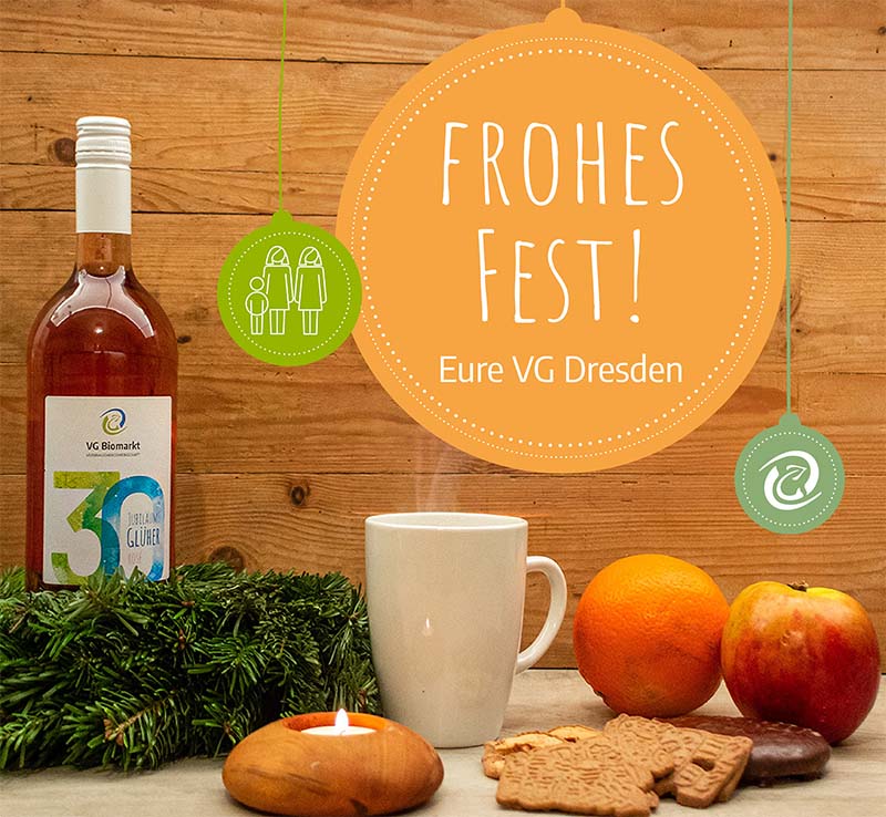 VG-Glühwein mit Weihnachtskranz und Keksen. Vor einem Holzhintergrund das Logo der VG und der Text "Frohes Fest - Eure VG Dresden"